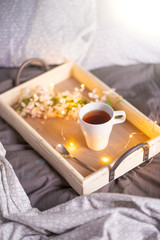 Fototapeta na wymiar morning breakfast tray, a cup of coffee or tea in bed, hotel service. women's Day. morning mood and warm