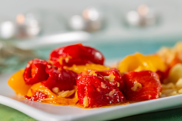Baked yellow red pepper on a white plate. Vegetarian food. Soft focus. Blurry backdrop. Closeup. Copy space.