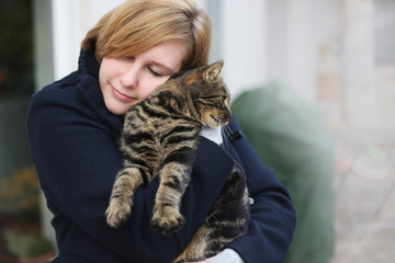 Junge Frau mit Katze auf dem Arm