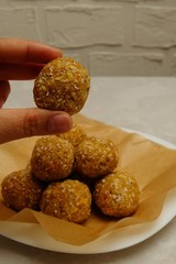 Energy balls - healthy snack rich with fibers and protein. No-bake recipe with walnuts, dried apricots and coconut flakes. Image with copy space, selective focus