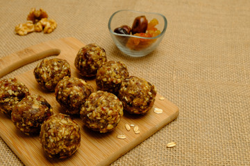 Energy balls - healthy snack rich with fibers and protein. Recipe with oats, walnuts, dates and raisins. Image with copy space,selective focus
