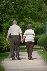 senior couple holds hands while they walk