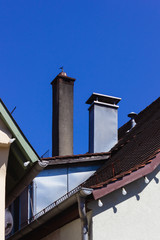 historical house facades and chimney on rooftops on blue sky