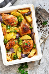Hot spicy chicken with potatoes and broccoli baked. Concrete background. View from above.