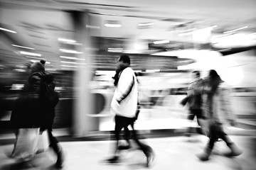 A shopper walking against shop window