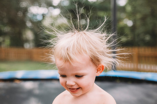 Toddler girl with wild static hair looking down