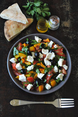 Middle Eastern cuisine. Vegetable salad with feta and parsley. Bright nutritious salad with feta vegetables and pita.
