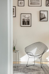 Stylish black metal chair in classy white living room interior with tenement house