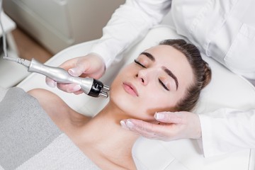Naklejka premium Girl lying on the couch on the skin rejuvenation procedure