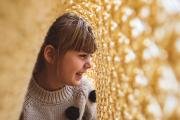 Girl laughing under a yellow blanket