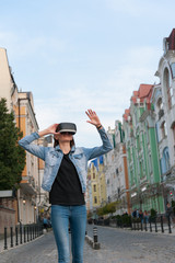 Beautiful young brunette wearing virtual reality headset in an urban context