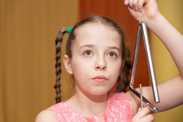 Mädchen mit Triangel schaut nachdenklich 