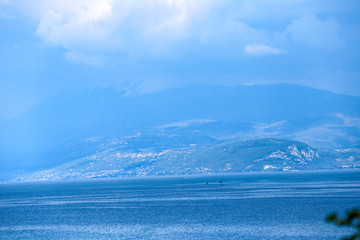 lake in the mountains with blue clouds and high rocks 