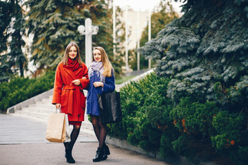 two beautiful and stylish girlfriends walking around the spring city with packages and shopping