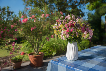 Fototapeta na wymiar bunter Blumenstrauß auf dem Gartentisch auf der Terrasse