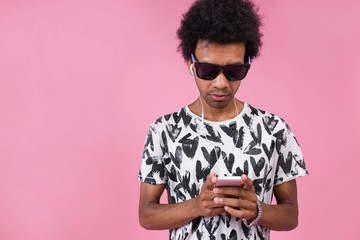 African man listening to music through headphones