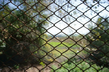 Closeup view of chain link fence with blurred background