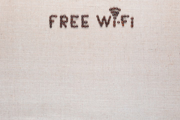 Free wifi sign made from coffee beans on linea background, shot top view, aligned top center.