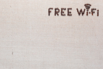 Free wifi sign made from coffee beans on linea background, shot top view, aligned top right.