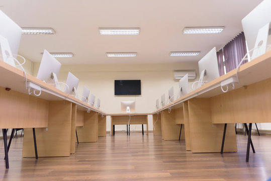 Modern Office With Computers On Desks. Empty Computer Room In College. Interior Of Classroom With Computers. Concept Of Corporate Working Space.