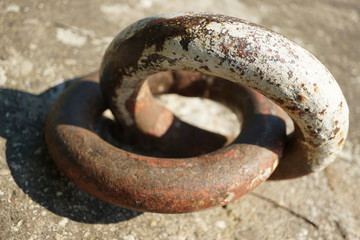 old rusty fixture for iron chains for ships on a riverbank