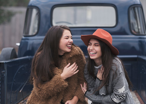 Happy brunette friend in the back of a vintage blue truck.