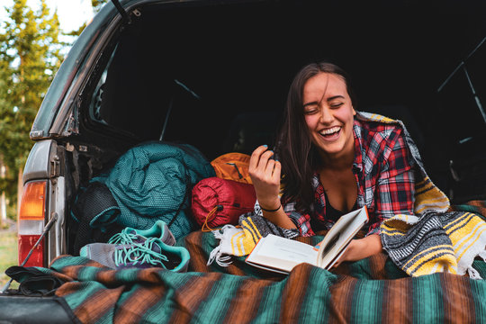 Camp Vibes - Young Woman Laughing while car camping.