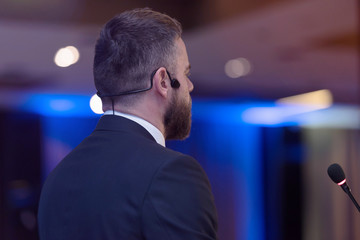 Young businessman at business conference room with public giving presentations. Audience at the...