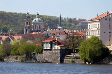 Spring green Prague baroque St. Nicholas' Cathedral with the Lesser Town above River Vltava in the...