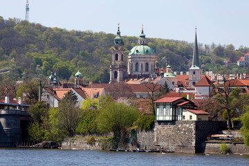 Spring green Prague baroque St. Nicholas' Cathedral with the Lesser Town above River Vltava in the...