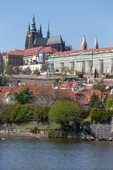 Spring green Prague Lesser Town with gothic Castle above River Vltava in the sunny Day, Czech...