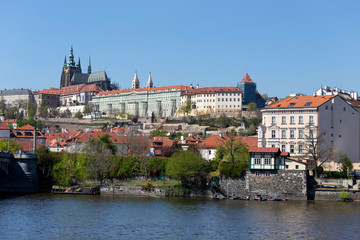 Spring green Prague Lesser Town with gothic Castle above River Vltava in the sunny Day, Czech...