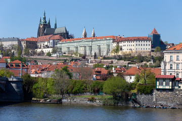 Spring green Prague Lesser Town with gothic Castle above River Vltava in the sunny Day, Czech...