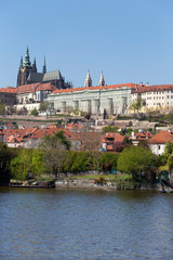 Fototapeta premium Spring green Prague Lesser Town with gothic Castle above River Vltava in the sunny Day, Czech Republic