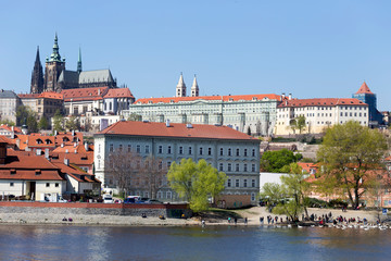 Obraz premium Spring green Prague Lesser Town with gothic Castle above River Vltava in the sunny Day, Czech Republic