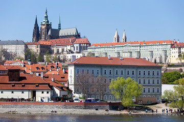 Spring green Prague Lesser Town with gothic Castle above River Vltava in the sunny Day, Czech...