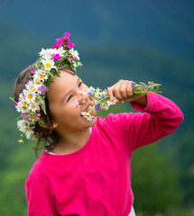 cute girl with flower crown smiling and having fun on meadow