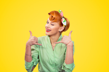 young woman making showing call me sign winking