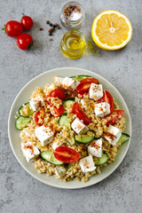 Middle Eastern cuisine. Vegetarian salad with bulgur, vegetables and feta cheese. Fresh bright arabic salad. Tabbouleh salad.