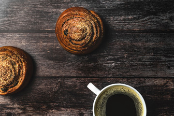 Perfect breakfast of homemade cinnamon buns and coffee on wooden table. Rustic style.