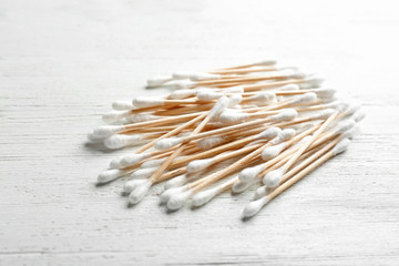 Pile of cotton swabs on white wooden background