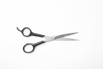 New scissors on white background, top view. Professional hairdresser tool