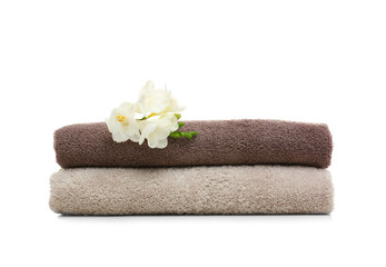 Obraz na płótnie Canvas Clean folded towels with flowers on white background