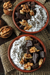 Keto breakfast or dessert. White yogurt with chia, walnuts and dark chocolate. Useful energy food. Eco food. Superfoods
