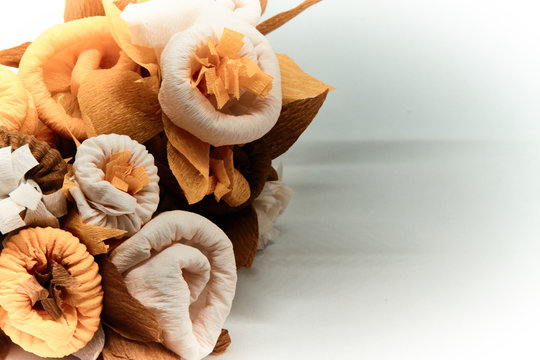 Bouquet of flowers made of couche gift paper insulated on a white and blurred background.