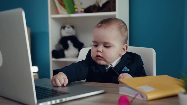 Kid boy businessman boss in office use laptop write notebook sitting play creative little happy job work child computer education young suit cute career confident close up slow motion