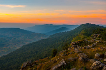 Landscape view poin field rock stone and sunset on hill top mountain orange sky forest background