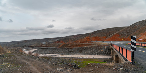 A view of colorful and brilliant  mountains with river and asphalt road.