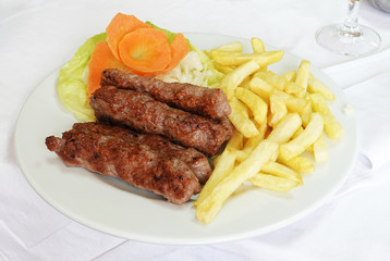 Grilled dish of minced meat called cevapcici with french fries