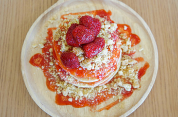 Pancakes strawberry fruit and sauce on wooden background